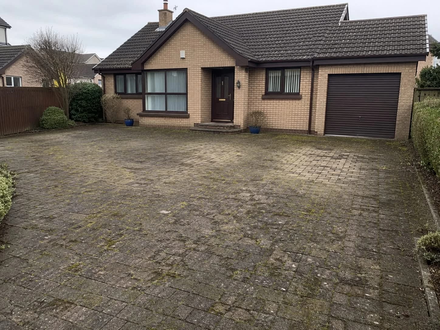 Moss-covered block-paved driveway in Limavady before pressure washing